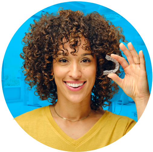 A woman stands confidently, holding a invisalign in her hand, ready for her dental care routine.