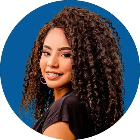 Young woman with curly hair and braces, smiling against a blue circular background. Illustrating adult braces in Sammamish and Kent, WA Young woman with curly hair and braces, smiling against a blue circular background. Illustrating adult braces in Sammamish and Kent, WA