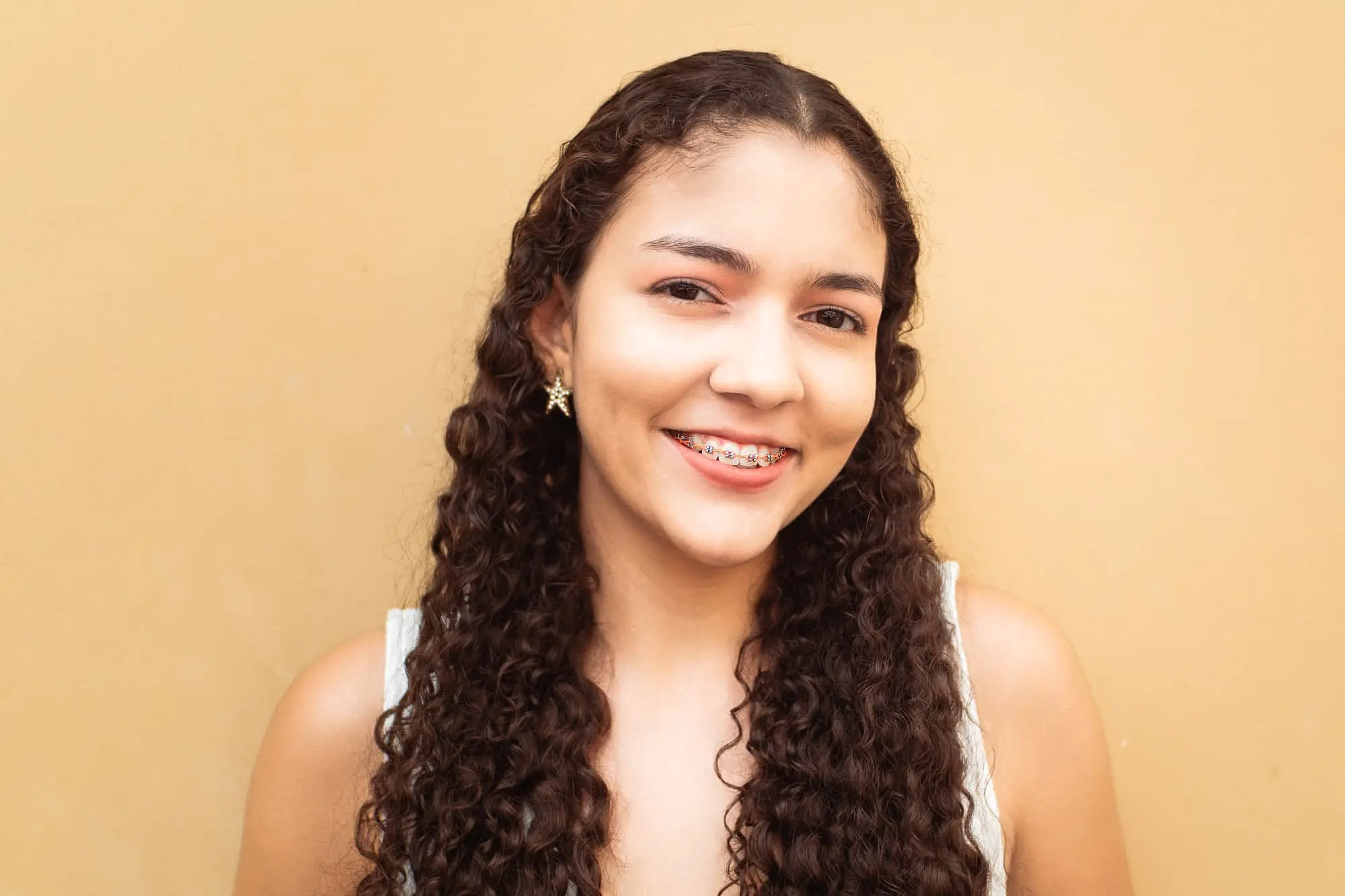 a woman proudly shows off her metal braces and get affordable Braces at Freelove Orthodontics in Sammamish or Kent, WA